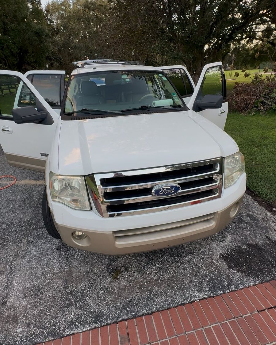 White Ford Expedition with doors open during an interior detail